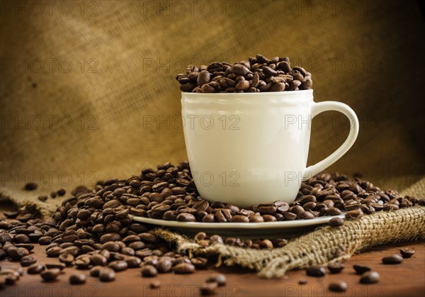 Coffee beans in cup and saucer