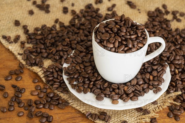 Coffee beans in cup and saucer