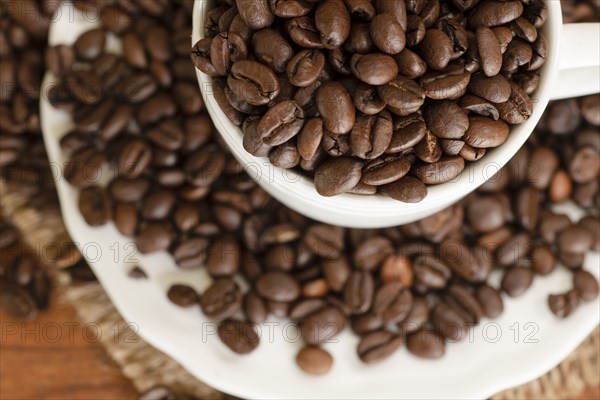 Coffee beans in cup and saucer