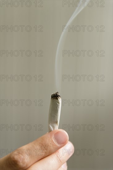 Hand of woman holding marijuana joint