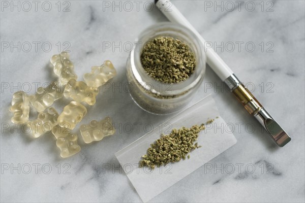 Gummi bear edibles, marijuana in jar and rolling paper, and electronic cigarette