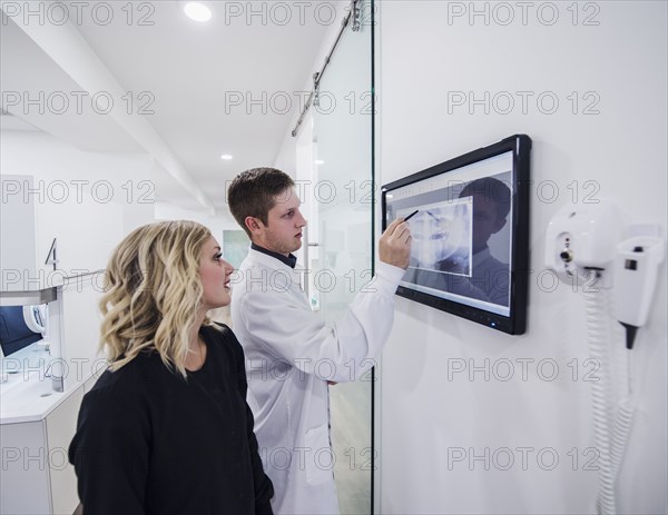 Dentist and assistant examining x-ray