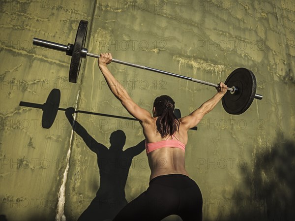 Woman weight lifting with barbell