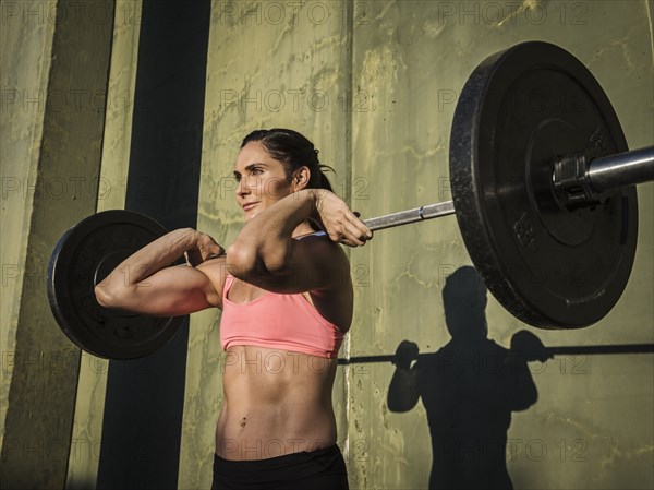 Woman weight lifting with barbell