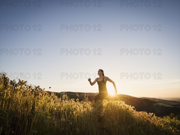 Mid adult woman jogging at sunset