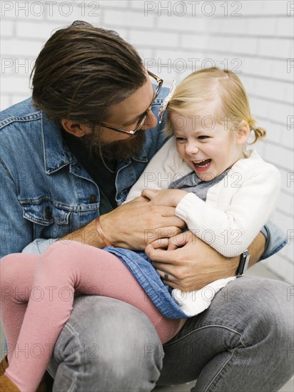 Man tickling his daughter