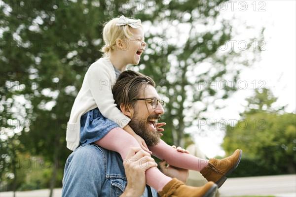 Father giving daughter piggyback ride