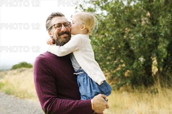 Girl kissing her father's cheek