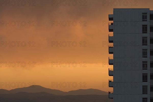 Distant wildfires and apartment building at sunset in Denver, Colorado