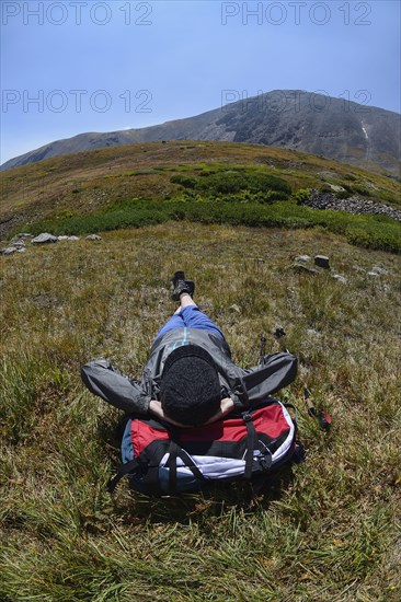 Woman resting on backpack while hiking on Silver Dollar Trail, Colorado