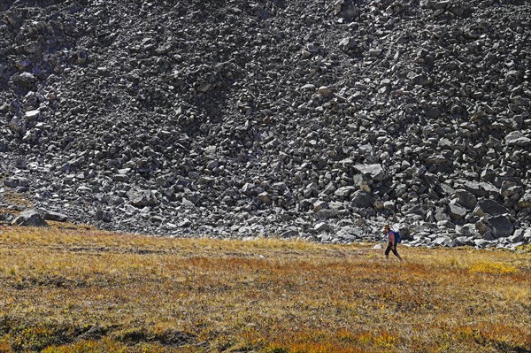 Woman hiking by talus slope in Mayflower Gulch, Colorado
