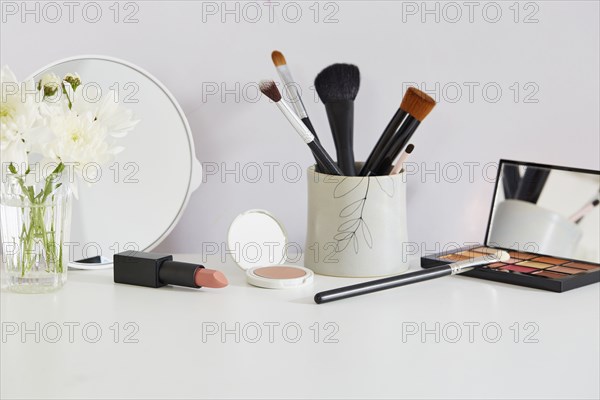 Flowers and make-up on white table