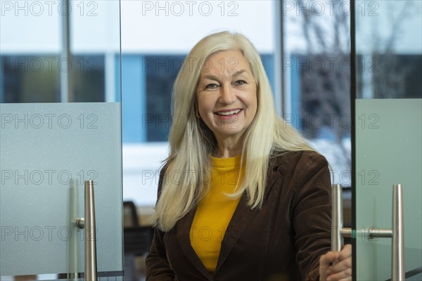 Smiling businessman opening door in office