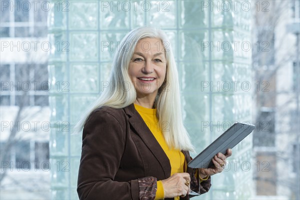 Smiling businesswoman with digital tablet in office