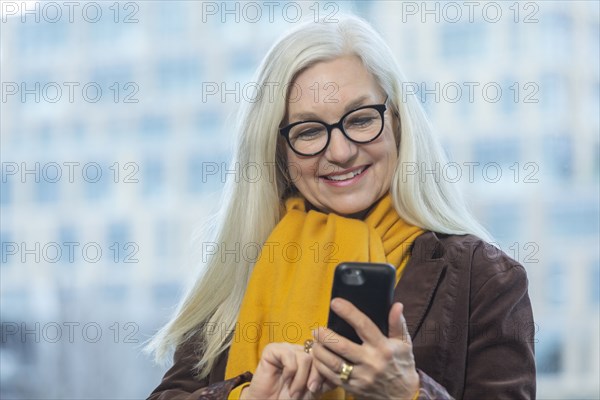 Smiling businesswoman with smartphone in office