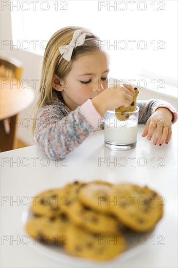 Girl eating milk and cookies