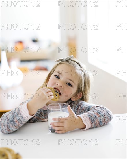 Girl eating milk and cookies