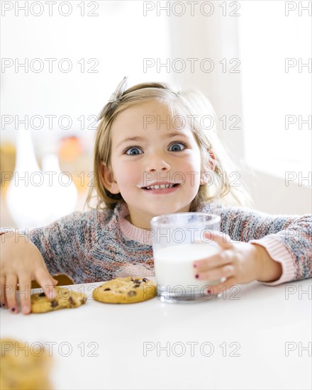 Girl eating milk and cookies