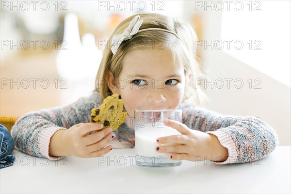 Girl eating milk and cookies