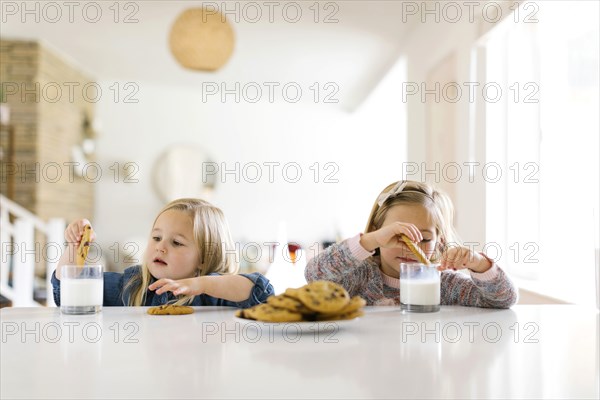 Girls eating milk and cookies