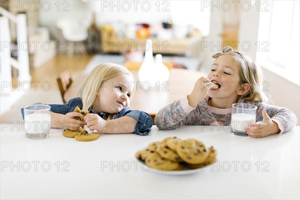 Girls eating milk and cookies