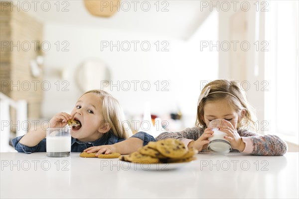 Girls eating milk and cookies