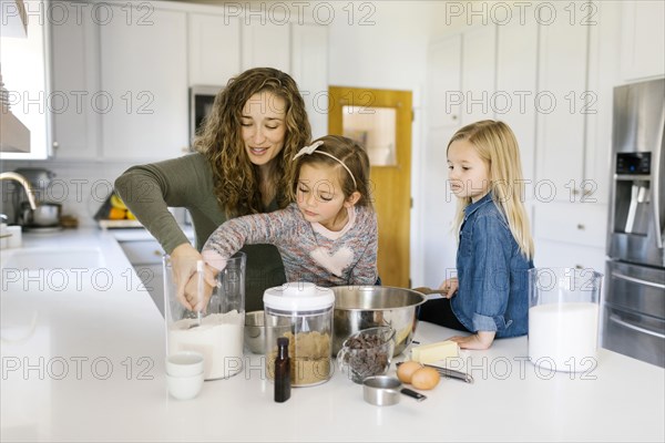 Woman baking cookies with her daughters