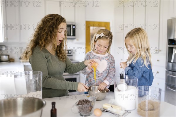 Woman baking cookies with her daughters