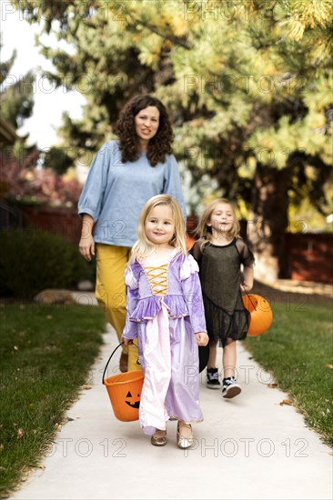 Girls in Halloween costumes with their mother