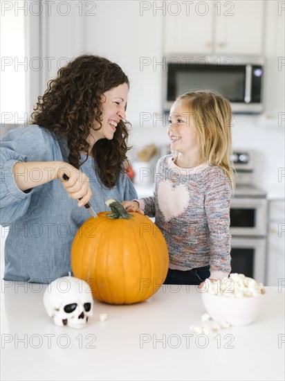 Mother and daughter carving pumpkin for Halloween