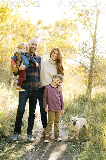 Family with pet dog on forest path