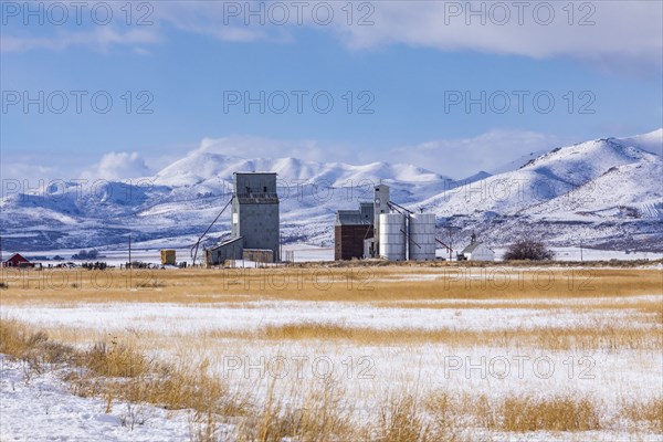 Farm in snowy field by mountains