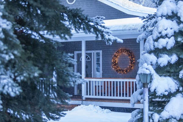 Illuminated Christmas wreath on house during winter