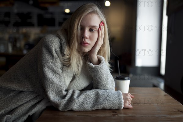 young woman sitting at cafe table