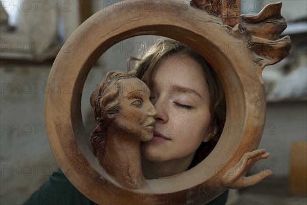 young woman and circular wooden sculpture