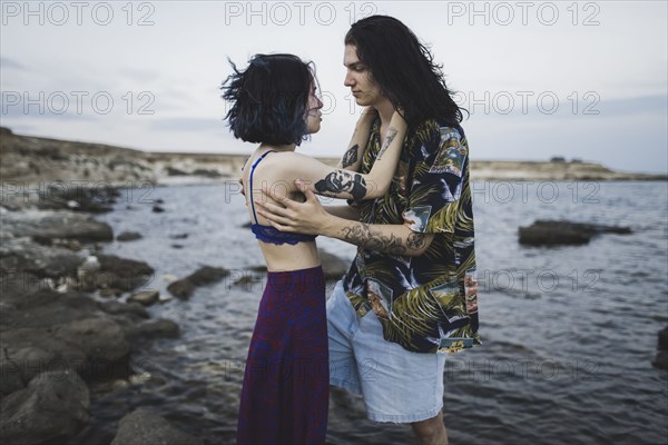 young couple face to face on beach