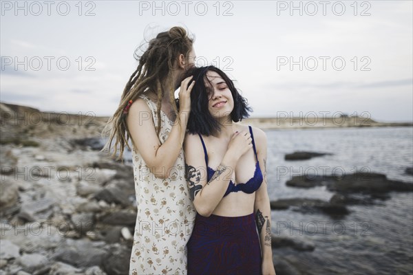 young women standing together on beach