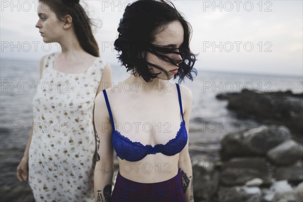 young women standing together on beach