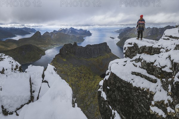 young woman in red hat and sweater on snowy mountain