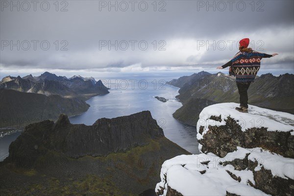 young woman in red hat and sweater on snowy mountain