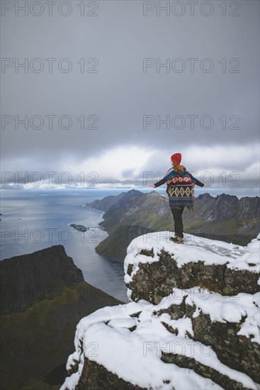 young woman in red hat and sweater on snowy mountain