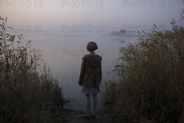 young woman by lake at sunset