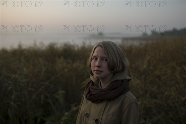 young woman in field at sunset