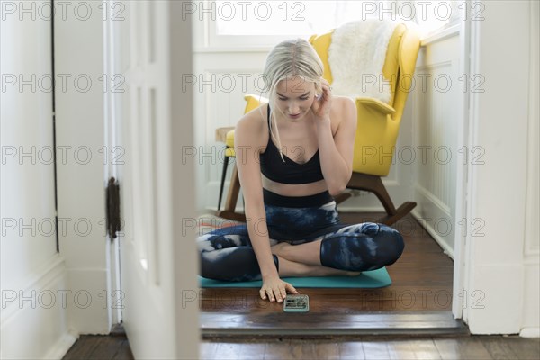 Woman working out at home with live stream on phone