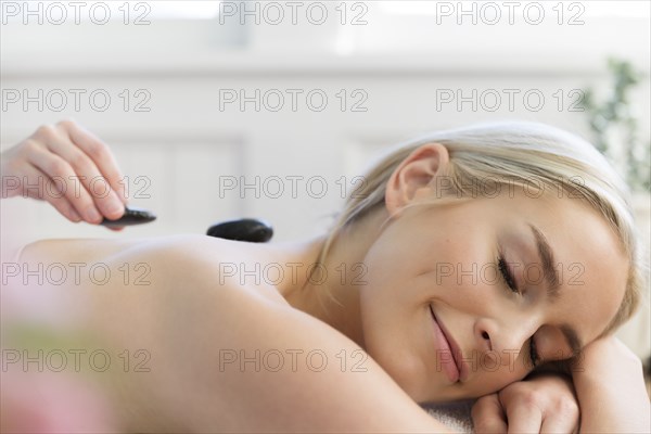 Woman receiving hot stone treatment at spa