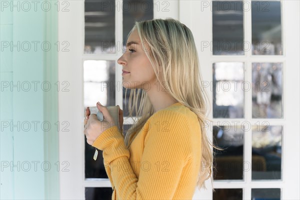 Portrait of woman in yellow sweater holding mug