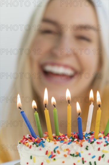 Woman smiling behind birthday candles