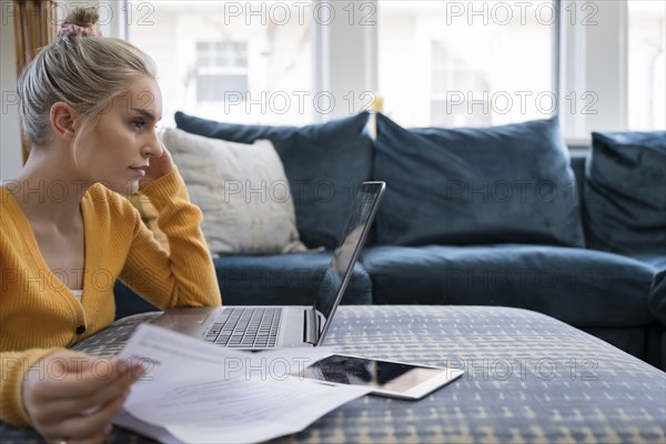 Woman working with laptop and paperwork