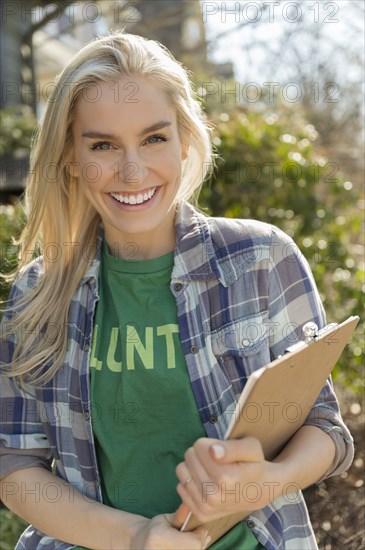 Smiling woman holding clipboard