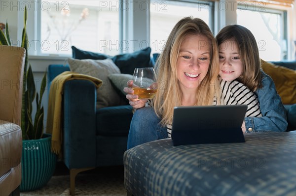 Mother and daughter (6-7) looking at laptop at home